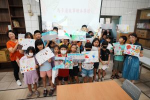 1 創作世界各國祭典的圖畫，大家手持自己的作品合影，展現跨文化學習與馬卡道文化韌性的傳承之美。